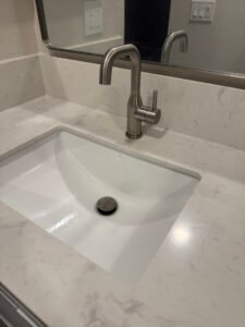 Bathroom faucet mounted above a white sink