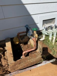 Exposed water-supply piping and valves beside a home