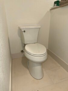 Toilet installed beside a bathroom wall