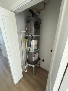 Tank water heater connected in a utility closet