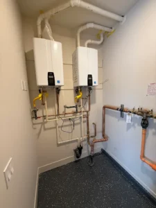 Two wall-mounted tankless water heaters with connected piping